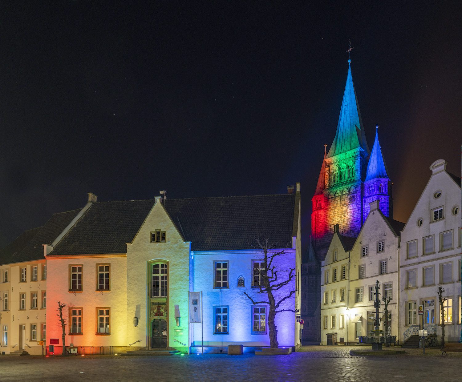 Kirchturm und Rathaus strahlen in Regenbogenfarben